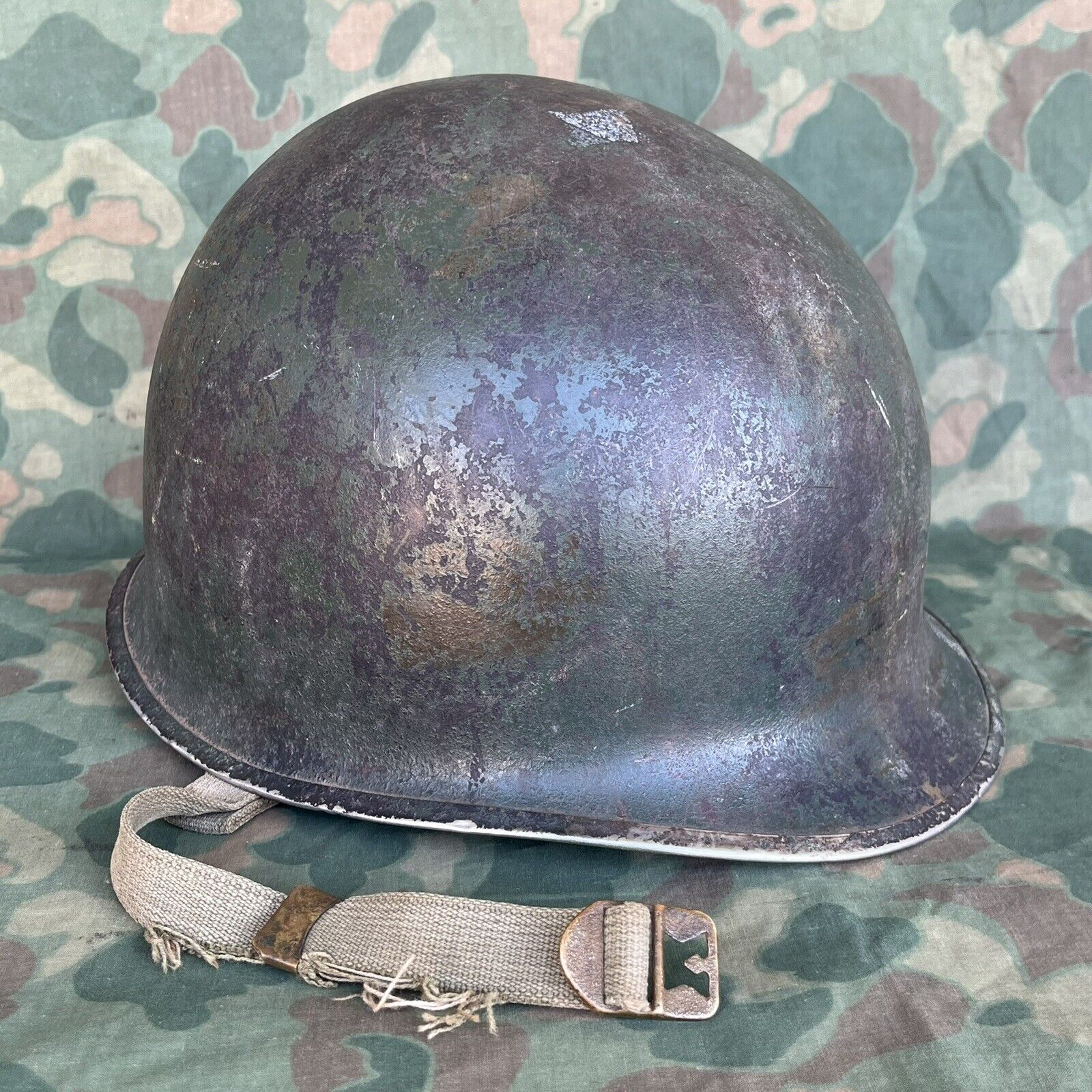 WWII US M1 Helmet With Camouflage Paint and St Clair Liner Rayon Battle Damaged